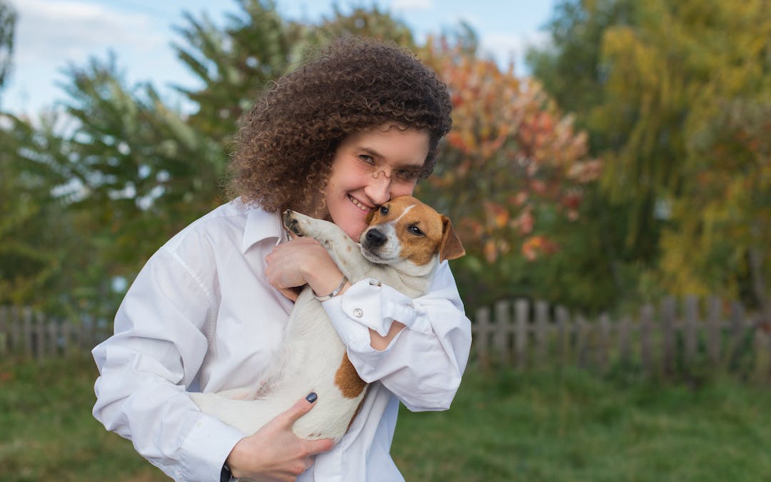 woman holding a dog outside